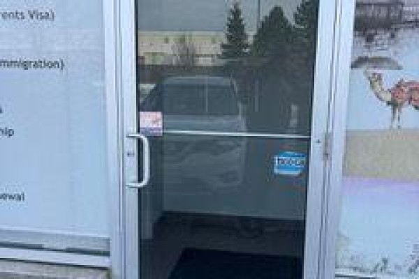 View through glass door to interior with signage and a dark floor. - 54 - 80 Maritime Ontario Boulevard N, Brampton