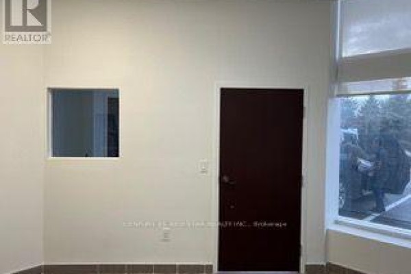 Interior wall with a small window, a dark brown door, and a large window. - 54 - 80 Maritime Ontario Boulevard N, Brampton