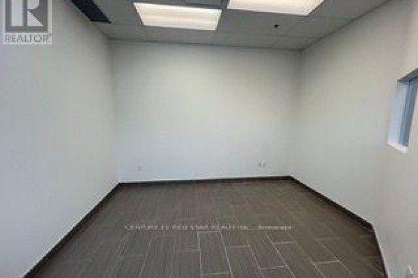 Empty commercial space with white walls, dark tiled floor, and overhead lighting. - 54 - 80 Maritime Ontario Boulevard N, Brampton