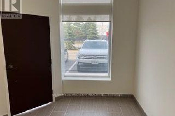 Interior wall with a dark brown door and a large window showing parked cars. - 54 - 80 Maritime Ontario Boulevard N, Brampton