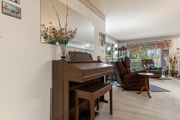 Open living and dining area with carpet, dining table, and entertainment center - 54 3110 Trafalgar Street, Abbotsford