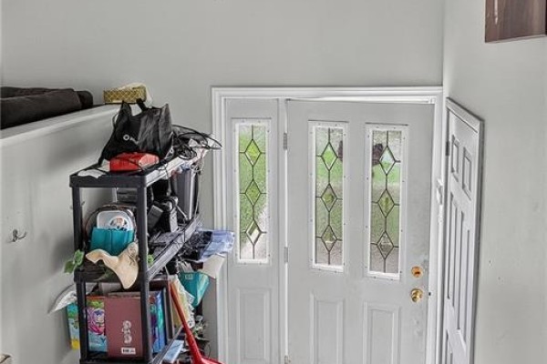 Interior view of a front entrance with white double doors featuring decorative glass panels. - 54-56 Northumberland Avenue, Saint John