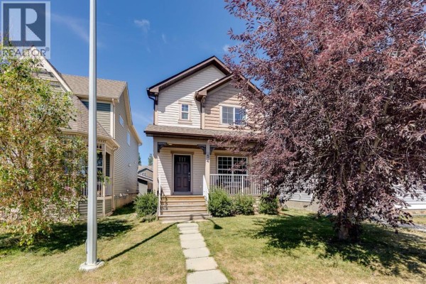 Front exterior view of the house showing the porch, windows, and surrounding lawn. - 54 Autumn View Se, Calgary