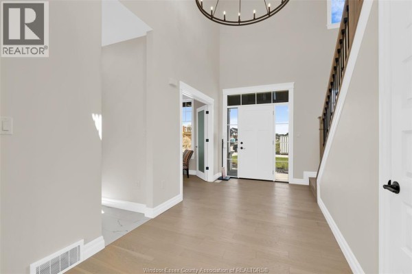 Two-story foyer with white double front doors, chandelier, and staircase. - 54 Belleview Drive, Kingsville