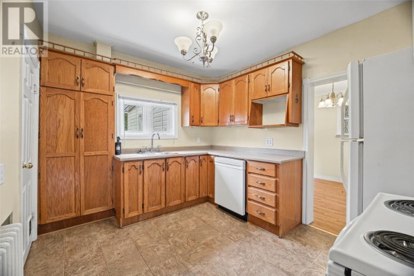 Kitchen with light wood cabinets, a white dishwasher, a double sink, and a white refrigerator. - 54 Belvedere Street, St Johns