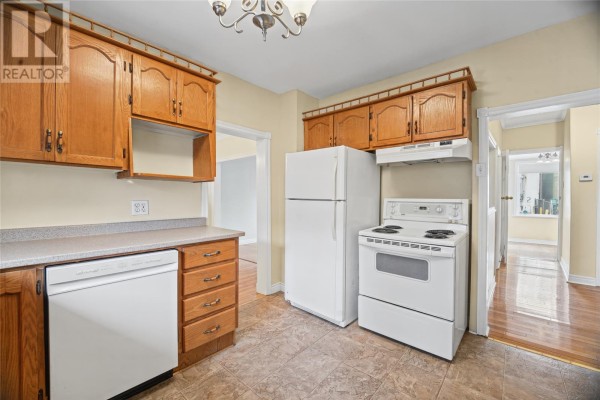 Kitchen with light wood cabinets, white appliances including a stove and refrigerator, and doorways to other rooms. - 54 Belvedere Street, St Johns