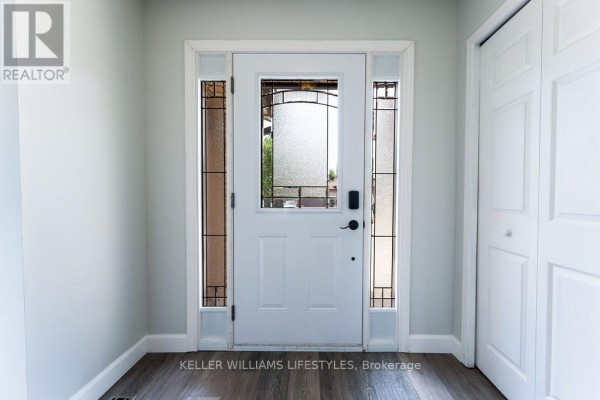 Interior front door with frosted glass sidelights, white trim, and light grey walls. - 54 Bexhill Drive, London South