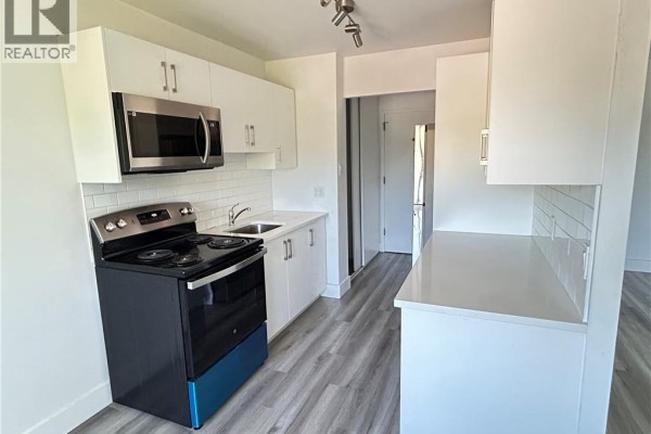 View of the kitchen from the other side, showing more white cabinets and countertop space. - 54 Country Hill Drive Unit# 318, Kitchener