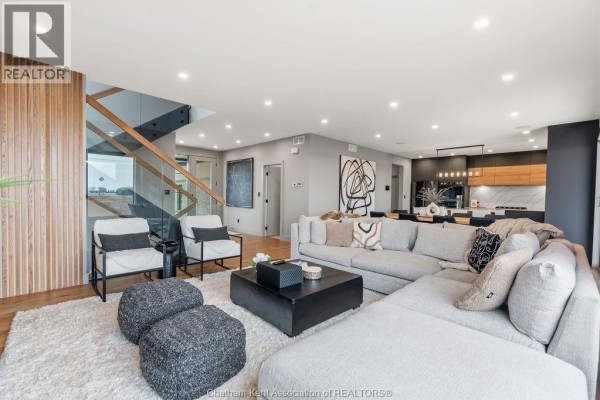 Sectional sofa, modern coffee table, and glass railing staircase - 54 Dundee Drive West Chatham