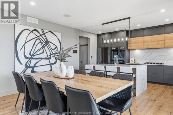Wooden dining table with black chairs, modern kitchen island & pendant light - 54 Dundee Drive West Chatham