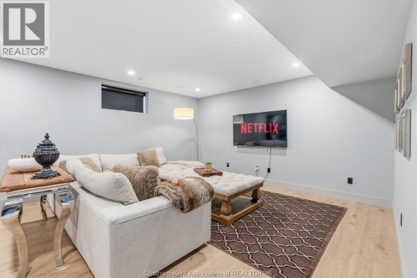 Living room with sectional sofa, ottoman, and mounted TV - 54 Dundee Drive West Chatham