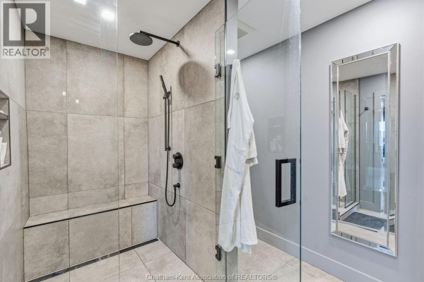Modern bathroom with glass shower, bench, and mirrored vanity - 54 Dundee Drive West Chatham