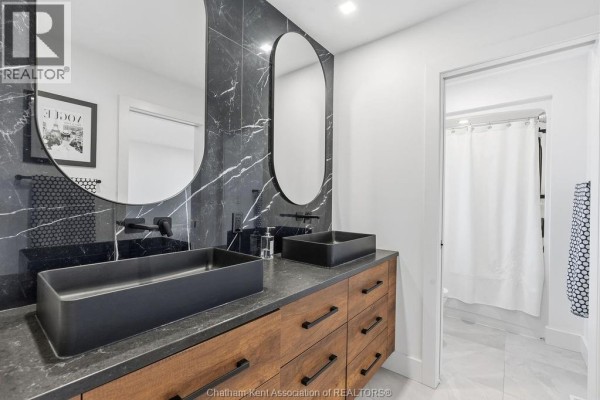 Modern bathroom double vanity with vessel sinks and marble backsplash - 54 Dundee Drive West Chatham