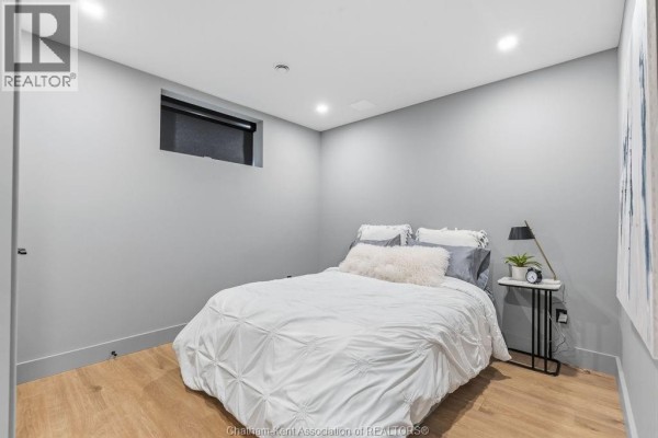 Queen bed with white duvet, nightstand with lamp and alarm clock - 54 Dundee Drive West Chatham
