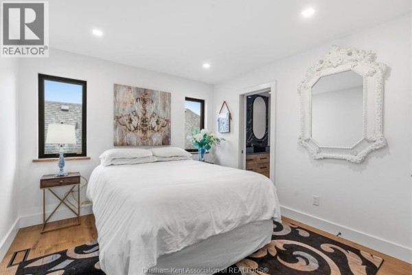 King size bed with ornate mirror and artwork - 54 Dundee Drive West Chatham