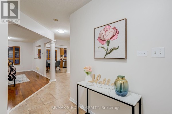Hallway view showing an entryway, columns, and an opening to the living area. - 54 Ferncroft Place, Brampton