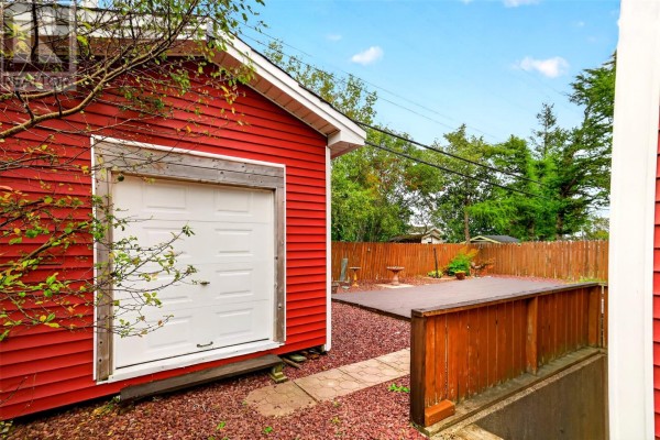Side of detached red garage with a white door and wooden trim. - 54 Halley Drive, St  John S