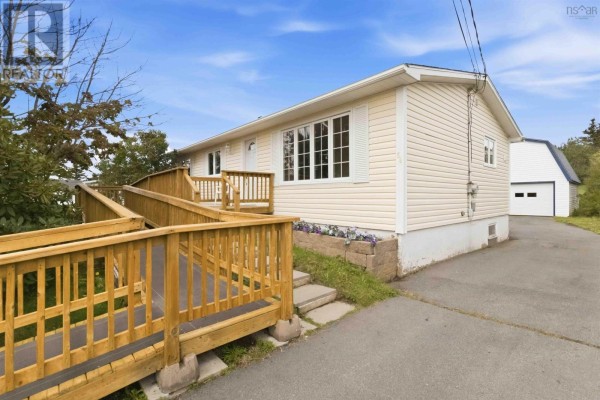 A wide green lawn with scattered trees and houses visible in the distance under a blue sky. - 54 Himmelman Drive, Eastern Passage