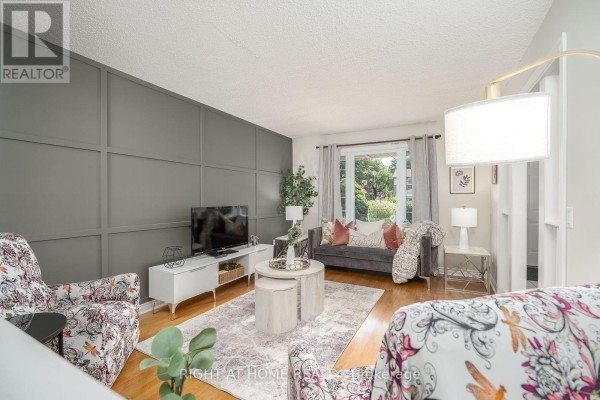 Entryway with hardwood stairs, decorative mirror, and light-colored walls - 54 Niagara Place, Brampton