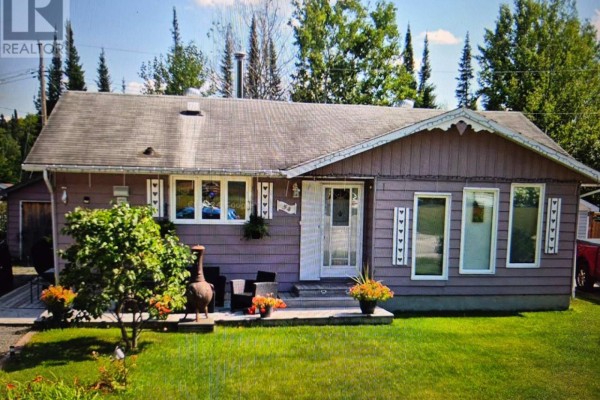Front exterior of a single-story, light purple wood-sided house with a grey roof and green lawn. - 54 Redwing Ave, Manitouwadge