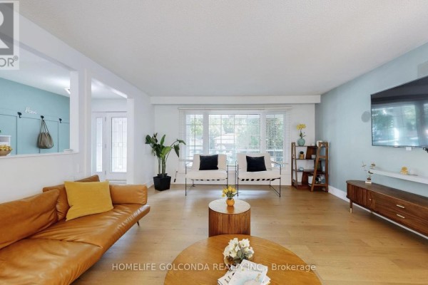 Living room with wooden flooring, two white chairs, and decorative shelving - 54 Senator Reesor's Drive, Markham