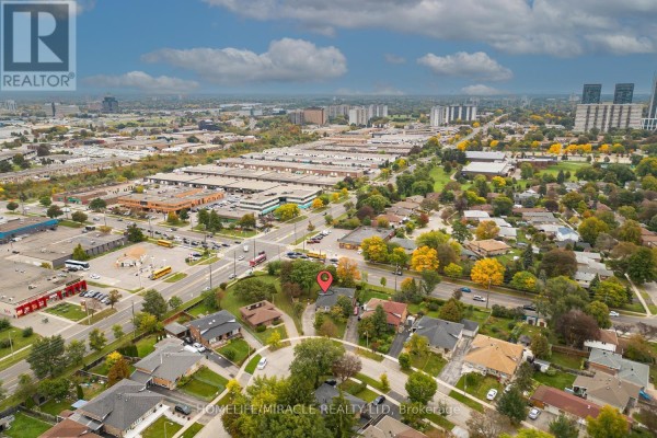 Aerial view of residential neighborhood with a detached house and distant city skyline. - 54 Sunderland Crescent, Toronto
