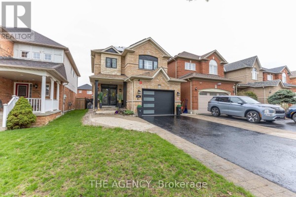 View of a brick house exterior with a manicured lawn and paved walkway. - 54 Thames Drive, Whitby