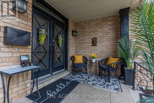 Covered front porch with double doors, seating, and potted plants. - 54 Thames Drive, Whitby