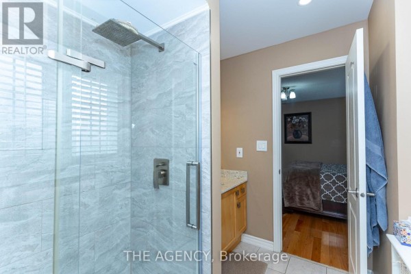 Interior foyer with double glass doors, beige walls, and a dark bench. - 54 Thames Drive, Whitby