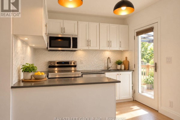 Empty bedroom with light grey walls, a window with roller blinds, and wood-look flooring. - 54 Thyra Avenue, Toronto