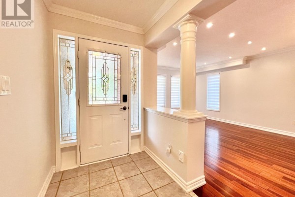 Interior view of the foyer with tiled floor, white door, and a glimpse into the open-concept living area. - 54 Treasure Road, Vaughan