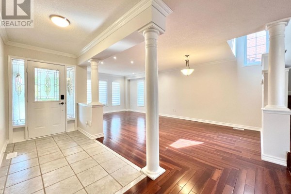 View of the foyer and open-concept living and dining area with dark wood floors and decorative columns. - 54 Treasure Road, Vaughan