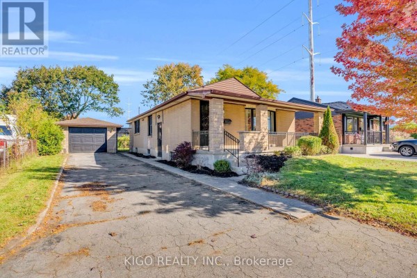 Front entrance of a brick bungalow with stone accents, a covered porch, and a bay window. - 54 Tweedsmuir Avenue, London East