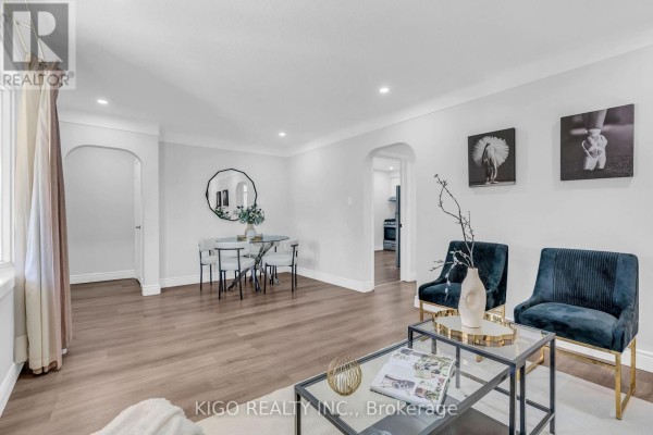 Living room with black leather furniture, a glass coffee table, and hardwood floors. - 54 Tweedsmuir Avenue, London East