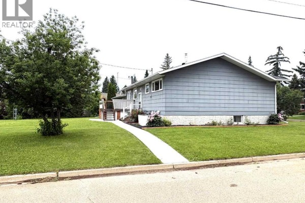 View of the side and front of a gray house with a white walkway and grass. - 5402 47 Avenue W, Forestburg