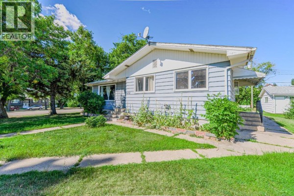 Kitchen with dark cabinetry, black countertops, and a large window overlooking the yard. - 5402 52 Street, Bashaw