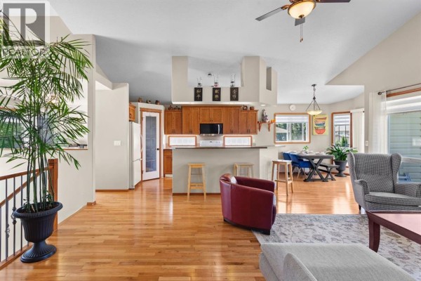 Open-concept living space with a kitchen island, dining area, and living room furniture. - 5408 59 Street, Camrose