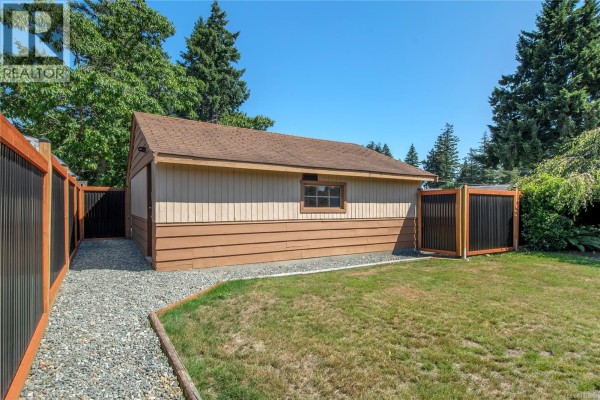 Exterior of a detached garage with a brown and tan finish and gravel pathway. - 541 Colwyn St, Campbell River