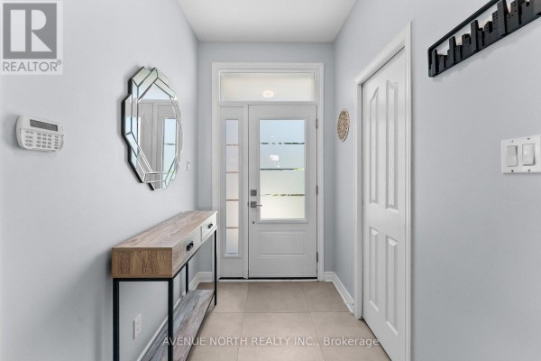 Interior entryway with light blue walls, beige tile floor, and a console table. - 541 Wild Shore Crescent, Ottawa