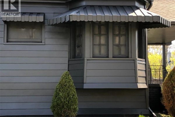 Close-up of bay window with awning and dark siding - 5425 Riverside Drive East, Windsor