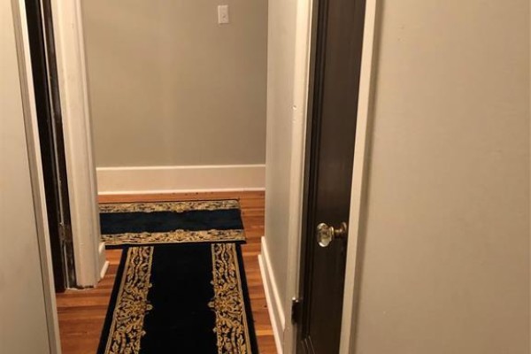 Hallway with hardwood floor and decorative runner - 5425 Riverside Drive East, Windsor