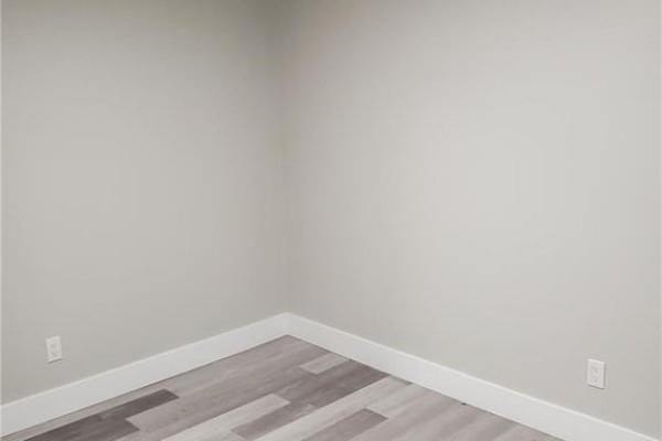 Empty corner room with light gray walls and laminate flooring - 543-545 Saint Anne Street, Bathurst