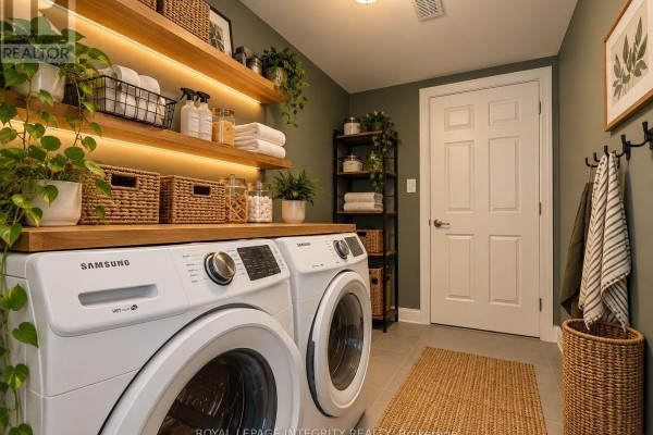 Laundry room with white Samsung washer and dryer, wooden shelves, and green walls. - 543 Ensatina Crescent, Ottawa