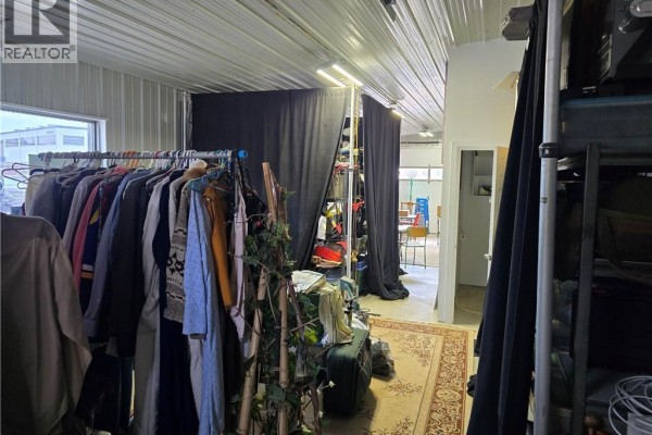 Interior view of a commercial space with clothing rack and black curtains. - 543 Greenwich Street Unit# 4, Brantford