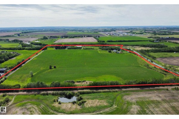 Aerial view of a large, rectangular field outlined in red, with rural properties and trees surrounding it. - 54318 Rge Rd 255, St  Albert