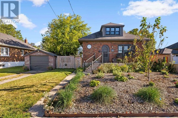 View of the brick house from the side with a landscaped front yard and walkway. - 545 Braidwood Avenue, Peterborough