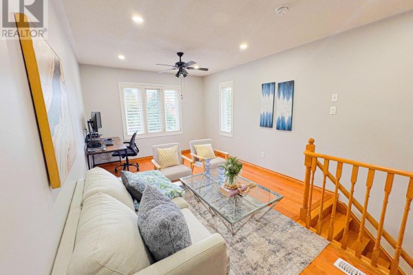 Living room with sofa, desk, armchairs, coffee table, and staircase - 5456 Palmerston Crescent Mississauga