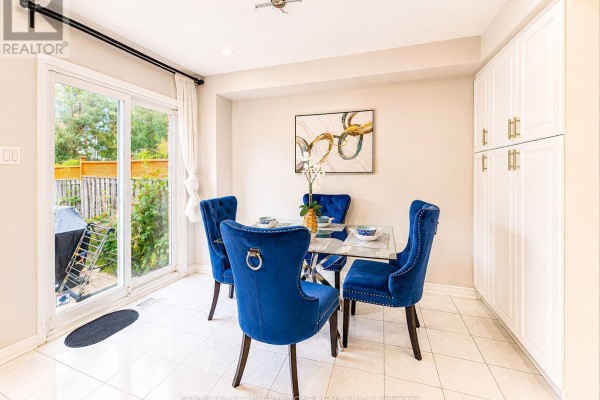 Dining area with glass table, blue velvet chairs, and pantry cabinets - 5456 Palmerston Crescent Mississauga