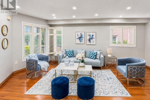 Blue sofa, accent chairs, and ottomans in a living room - 5456 Palmerston Crescent Mississauga