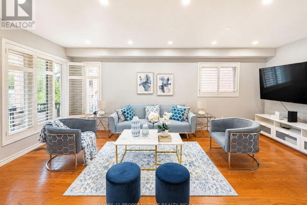 Living room with blue sofa, accent chairs, marble coffee table, and TV - 5456 Palmerston Crescent Mississauga